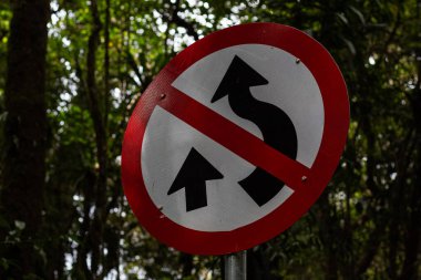 Döner yol işareti metalden yapılmıştır ve kırmızı ve beyazdır..