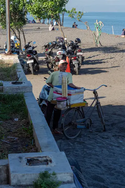 Dondurma satıcısı, 14 Temmuz 2024 'te Loang Baloq plajında bisikletle Endonezya' nın Lombok şehrinde satılıyor.