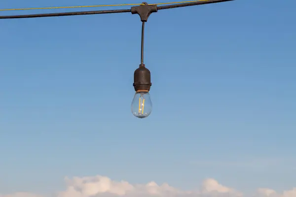 stock image Light bulbs on a bright and slightly cloudy blue sky background