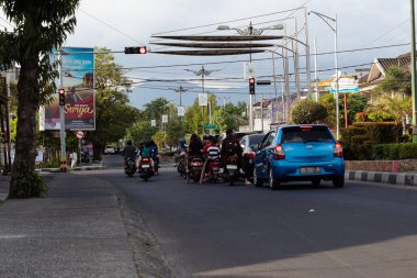 Mataram, Lombok, Endonezya 'da işlek bir şehir sokağındaki trafik ışıklarında motosikletli ve arabalı insanlar bekliyor - 24 Ağustos 2024