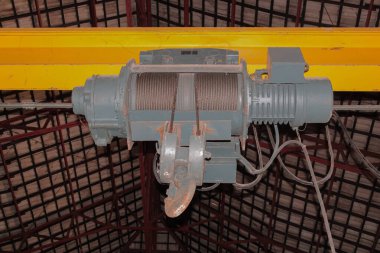 Endüstriyel vinç kaldırma mekanizması tel ip ve kancayla bir depoya bağlanıyor.