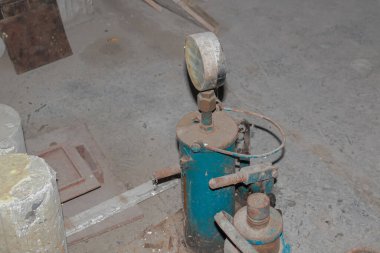 Beton zeminde göstergesi olan eski endüstriyel basınç test ekipmanlarının yakın görüntüsü