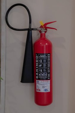 Red Fire Extinguisher Mounted on Wall for Emergency Fire Safety at Mataram, Indonesia on November 9, 2024