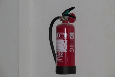 Red Fire Extinguisher Mounted on Wall for Emergency Fire Safety at Mataram, Indonesia on November 9, 2024