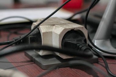 Çoklu bujili ve karışık kablolu bir elektrik güç şeridinin yakın görüntüsü