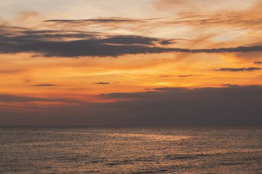Güzel turuncu gökyüzü ve bulutlar huzurlu akşam deniz manzarası boyunca