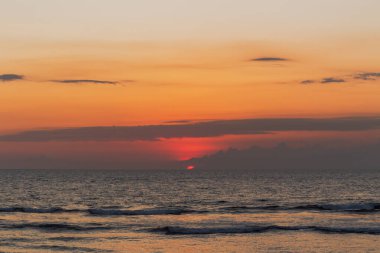 Okyanusun üzerinde dramatik renkli bulutlarla güzel bir tropikal gün batımı