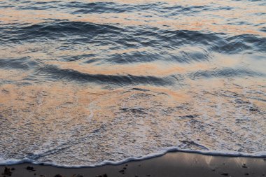 Okyanus Dalgalarının Yakından Görüntüsü Gün batımında Kum Sahil Şeridine Nazikçe Kapanıyor