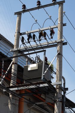 Şehir elektrik dağıtım transformatörünü çevreleyen karmaşık elektrik hatları ağı.