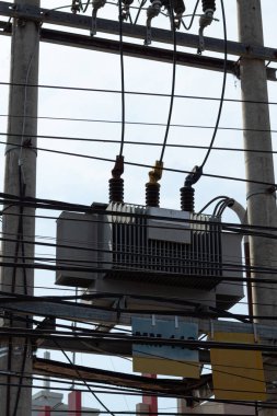 Şehir elektrik dağıtım transformatörünü çevreleyen karmaşık elektrik hatları ağı.