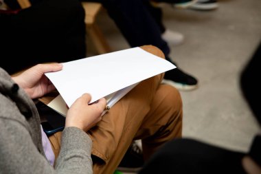 Elinde boş bir kağıt tutan bir adamın yakın görüntüsü. 