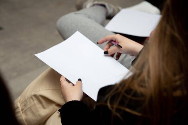 Boş kağıt tutan genç bir kadının kesilmiş görüntüsü.