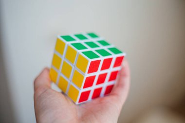 Kadın elleri bir rubik küp tutuyor.