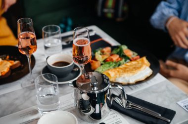 Restoran masasında yeşil marul yapraklı ve somon dilimli omlet.