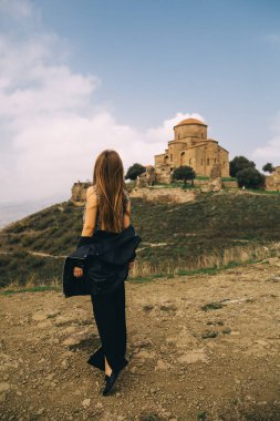Mtskheta, Georgia 'daki Jvari Manastırı' nın yanında duran güzel genç bir kadın.