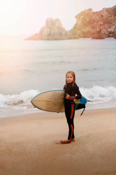Kleine Surfer Met Surfplank Kijkend Naar Camera Tijdens Zonsopgang — Stockfoto