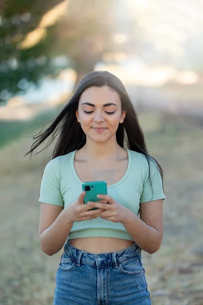 美しいですブルネット女の子でザ田舎で使用してスマートフォン — ストック写真