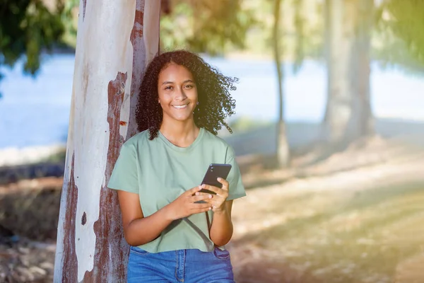 Krásná Usměvavá Dívka Kudrnatým Účesem Pomocí Chytrého Telefonu Během Letního Stock Obrázky