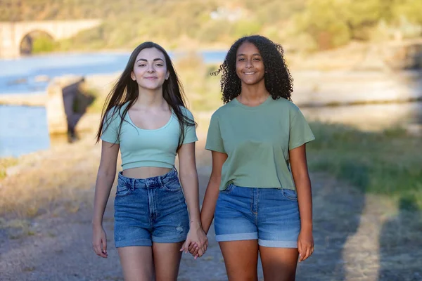 晴れた日に川の近くを歩く田舎の2人の女の子の友人 — ストック写真