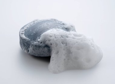 Beyaz arka planda köpüklü katı sabun. Doğrudan yukarıdan bakıldığında.