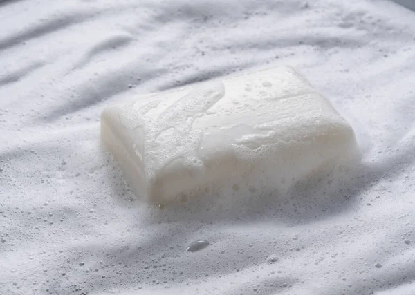 stock image White solid soap placed against a background of foam. 