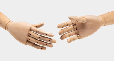 Two wooden mannequin hands on white background. Shaking hands. Business concept.