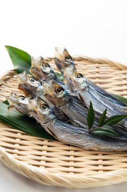 Urume sardines served in a colander placed on a white background. Japanese food, dried fish.