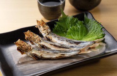 Grilled urume sardine placed on the table. A side dish of sake. Japanese food image.