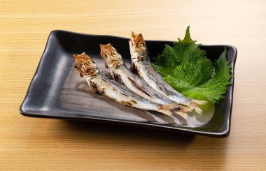 Grilled urume sardine placed on the table. A side dish of sake. Japanese food image.