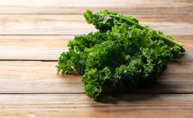 Kale placed against a wooden background. curly kale. clipart