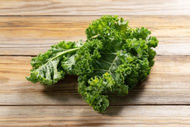 Kale ahşap bir arka plana yaslanmış. kıvırcık lahana.