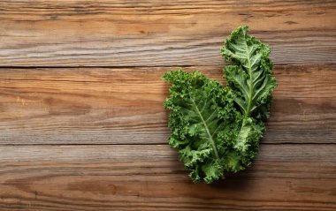 Kale ahşap bir arka plana yaslanmış. kıvırcık lahana