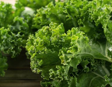 Kale ahşap bir arka plana yaslanmış. kıvırcık lahana