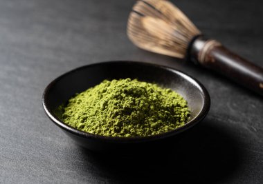 Matcha ve Chasen siyah arka planda. Kibrit tozu. 