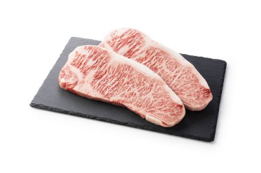 Taze çiğ bifteği taştan bir tabağa koyup beyaz arka plana koymuşlar. Wagyu bifteği..