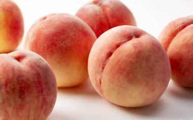 Japon şeftalileri beyaz arka plana yerleştirilmiş. Yakın plan..