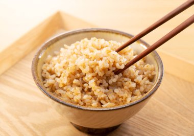 Taze pişirilmiş kahverengi pilav, çubuklarla kaldırılmış.