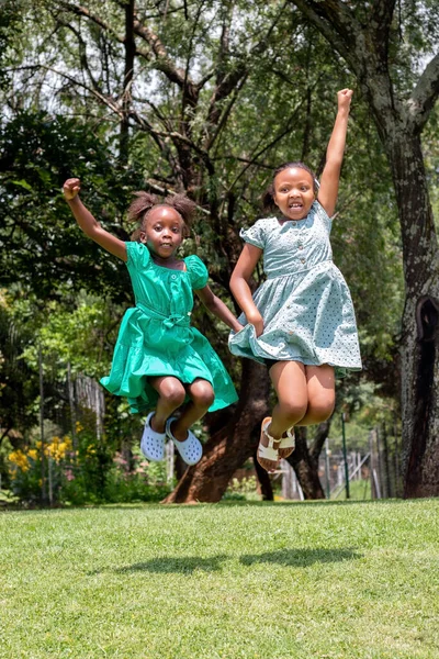 Full Length Portrait Two African Girls Jumping Together Green Garden — Fotografia de Stock