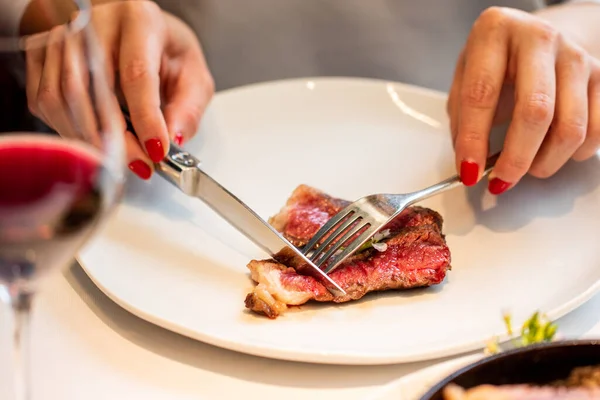 女性の手の詳細を閉じるグルメレストランでサーロインステーキを切断 — ストック写真
