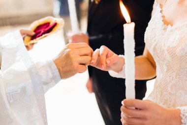 Gelin ve damat kilisede rahibin önünde. Nikah yüzüklerinin değiş tokuşu