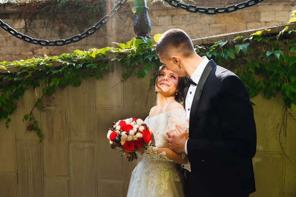 Великолепная Невеста Стильный Жених Нежно Обнимаются Фоне Стены Букет Невесты — стоковое фото