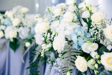 Yeni evliler masasının zarif alanı farklı renklerle dekore edilmiştir. Düğün ve tören yerinin güzel çiçek süslemesi, ayrıntılar.