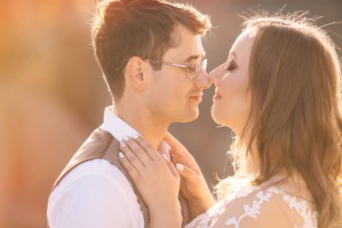 Mutlu gelin ve damadın güneş ışığı portresi gün batımında doğa alanında. Sıcak yaz zamanı.