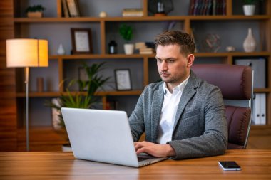 İş yerinde kendine güvenen bir uzman. Onun iş yerinde otururken onun laptop kullanarak Pensive genç yakışıklı adam