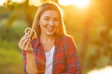 Gülümseyen genç bir kadın diş telleri, diş sağlığı hizmetleri ve ortodontik konsept taşıyor.