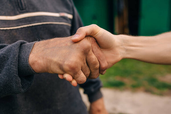 Senior man and young man holding hands