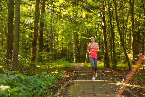 Yaz parkında koşan bir bayan koşucu. Sağlıklı kadın dışarıda koşuyor..
