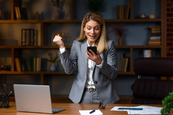 Portrait of young Happy excited  businesswoman in office working with mobile phone,Yes great job.Portrait of young Happy excited  businesswoman in office working with mobile phone,Yes great job.