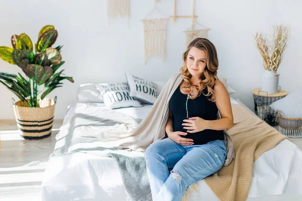 Feliz Embarazada Sentado Sofá Casa Dormitorio Abrazando Vientre — Foto de Stock
