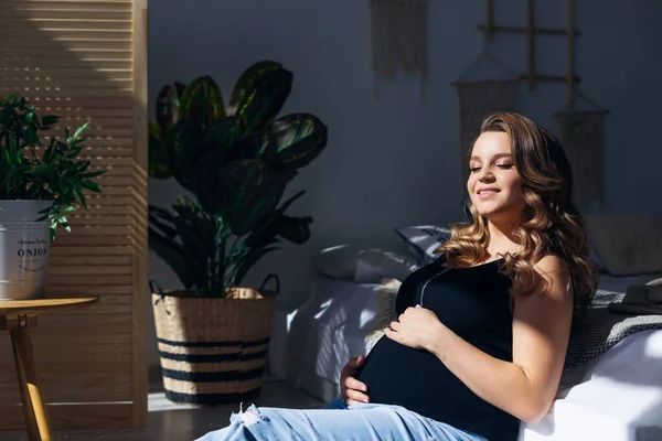 여성이 웃으며 소파에 느낀다 임신부들 휴식을 취하게 — 스톡 사진